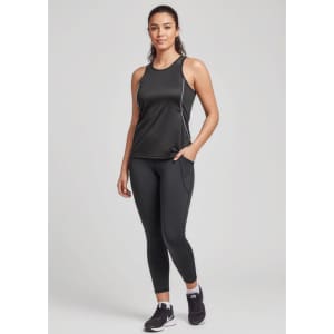 A woman wearing black Luna 7/8 length leggings and a matching tank top, standing confidently with one hand on her hip.