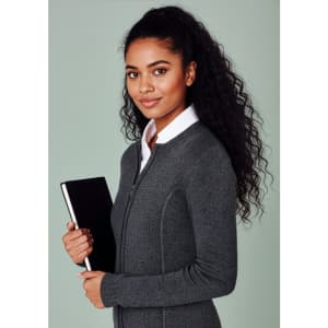 A woman with curly hair wearing a grey 2-way zip cardigan, holding a notebook. The cardigan features a fitted design.