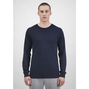 A long sleeve tee in navy blue, displayed on a model against a plain background. The garment has a logo.