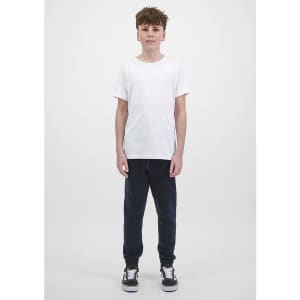A young person is wearing navy track pants and a plain white t-shirt, standing against a light background.