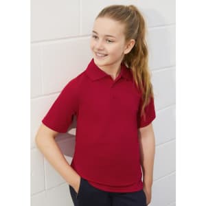 A red short sleeve polo shirt featuring a collar, designed for kids, with one logo present.