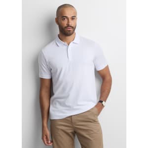 A white short sleeve polo shirt with a collar, worn by a man standing against a light background.