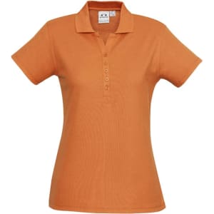 An orange ladies polo shirt with a collar and button placket, featuring a logo on the chest.