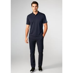A navy short sleeve polo shirt worn by a model, paired with matching navy trousers and black shoes.