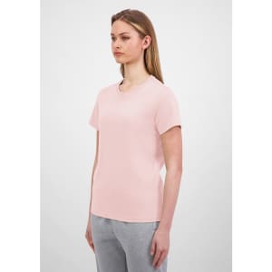 A light pink women's short sleeve tee displayed on a model with straight hair, paired with grey bottoms.