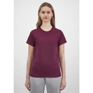 A woman wearing a maroon short sleeve tee, featuring a simple design and a round neckline.