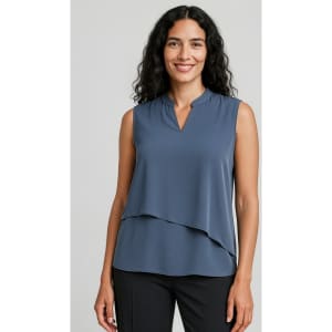 A sleeveless layered blouse in a soft blue hue, featuring a v-neckline and loose fit. The model is smiling, showcasing the top.