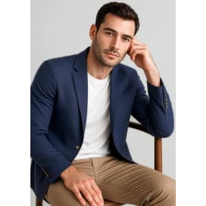 A navy blue men's blazer worn over a white t-shirt, paired with tan trousers, featuring a logo on the blazer.