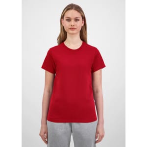 A women's short sleeve tee in red, showcased on a model with light brown hair, paired with grey bottoms.