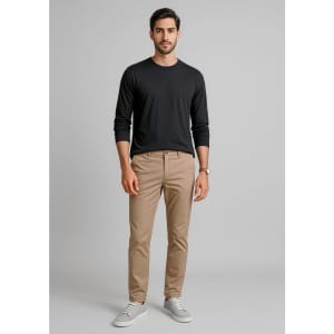 A pair of men's tapered stretch chino pants in beige, paired with a black long-sleeve shirt and white sneakers.