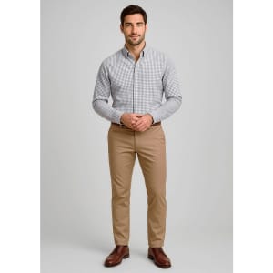 A man stands wearing a checked shirt and light brown modern stretch chino pants, with a logo on the pants.