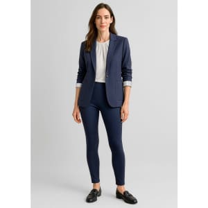 A woman wearing a navy blazer and high-rise navy leggings, styled with a white blouse and loafers.