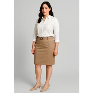 A woman stands wearing a beige mid waist stretch chino skirt and a white shirt, with a logo visible on the skirt.