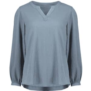 A light blue long sleeve blouse featuring a V-neck and ruché detailing. The blouse has a subtle texture and a relaxed fit.