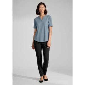 A blue short sleeve blouse on a model, paired with black trousers and black shoes. The blouse has a subtle neckline detail.