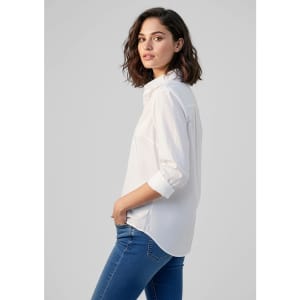 A white women's long sleeve button-up shirt, featuring a relaxed fit and rolled sleeves. It has a subtle logo.
