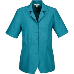 A short-sleeved overblouse in teal, featuring a collar and a pocket, with a logo on the upper left side.