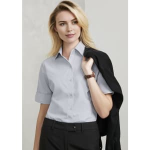 A light grey short sleeve button-up shirt for women, featuring a collar and rolled sleeves.