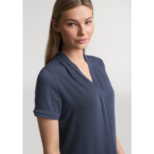 A womens short sleeve shirt in navy blue with a v-neckline and rolled sleeves. Features a subtle logo.