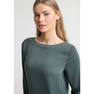 A women's boatneck top in green, featuring long sleeves and a smooth fabric. The design includes a subtle brand logo.