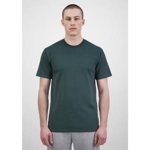 A plain green men's short sleeve tee, displayed on a model, paired with grey trousers. The shirt has a subtle logo.