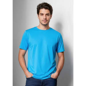 A blue short sleeve men's T-shirt, featuring a round neck and a smooth fabric finish. The model stands casually, hands in pockets.