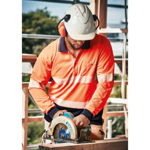 A person wearing an orange long sleeve polo shirt with segmented reflective tape operates a circular saw, wearing a helmet and ear protection.