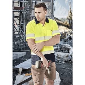 A short sleeve polo shirt in hi-vis yellow with segmented reflective tape, paired with khaki shorts and a tool in hand.