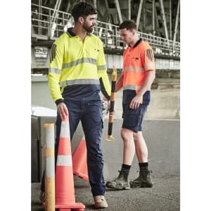 A long sleeve polo in high visibility yellow and orange with reflective tape, worn by two men in work settings.