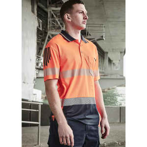 A man wearing a high-visibility orange and navy short sleeve polo with segmented reflective tape and a logo.
