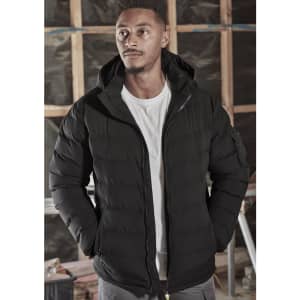 A black unisex hooded puffer jacket with a zip front, worn by a model in a construction setting.