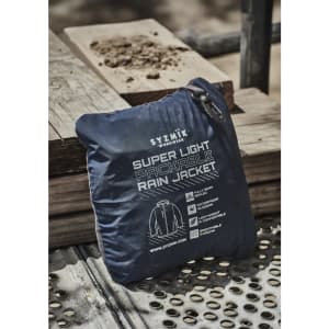 A navy blue packable rain jacket neatly folded and zipped, featuring a logo and information on the packaging.