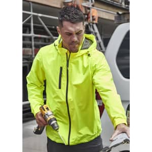 A man wearing a bright yellow unisex super light packable rain jacket, holding a drill and working outdoors.