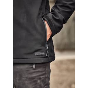 A black softshell jacket with a zippered pocket, featuring a logo and a hand tucked into the side.