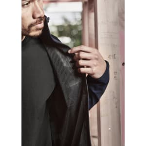 A navy unisex waterproof jacket with a mesh interior, showcased by a person holding back the fabric.
