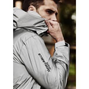 A reflective grey waterproof jacket with a logo, featuring a close-up of a model wearing it.