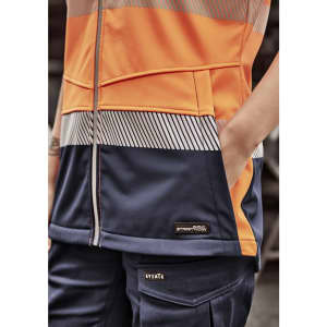 A softshell jacket in orange and navy with a zip front and pockets, featuring a logo on the side.