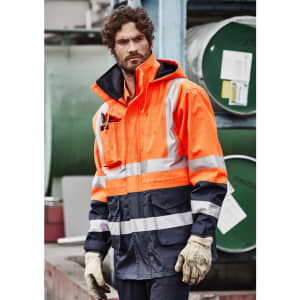 An orange and navy waterproof jacket with reflective stripes, featuring a hood and pockets, worn by a model.