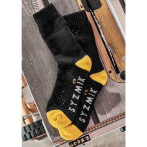 A pair of black and yellow work socks with branding, displayed on a wooden surface.