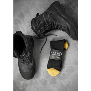 A pair of black work boots alongside a black and yellow sock with a logo.