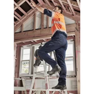Mens summer cargo pants in navy, featuring multiple pockets, worn by a worker on a ladder in a construction setting.