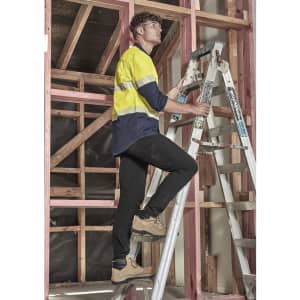 Lightweight black cargo pants worn by a man climbing a ladder in a building under construction.
