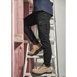 Men's lightweight outdoor cargo pants in black, featuring multiple pockets, worn while climbing a ladder.