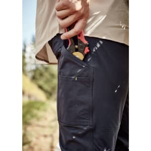 Lightweight navy cargo pants with a pocket holding gardening shears, worn with a light-coloured shirt, set in an outdoor environment.