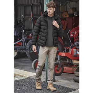Men's essential basic stretch cargo pants in beige, paired with a black puffer jacket and tan boots, set in an outdoor environment.