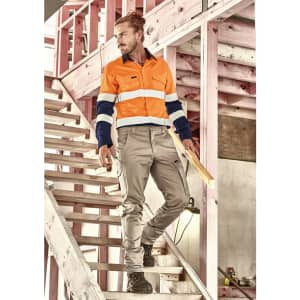 Men's essential basic stretch cargo pants in beige, featured with a logo, paired with an orange and navy work shirt.