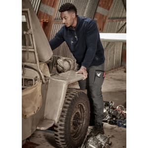 Men's Streetworx Heritage Pant in dark grey, worn by a man working on a vehicle in a garage setting.