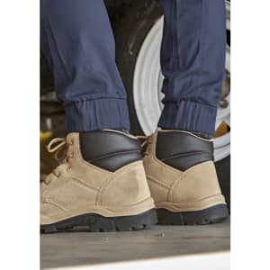 A pair of cuffed navy work pants worn with tan and black boots, set against a vehicle backdrop.