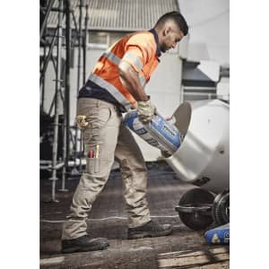 Men’s rugged cargo pants in beige, featuring multiple pockets, worn with an orange high-visibility shirt and black boots.