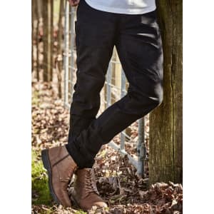 Black stretch jeans with a slim fit, paired with brown boots, set against a natural outdoor background.